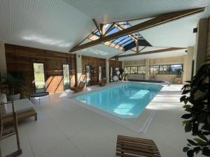 a large swimming pool in a house with a ceiling at Villa NOVA in Saint-Hilaire-de-Riez