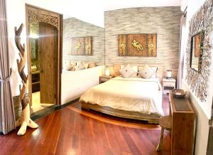 um quarto com uma cama e uma mesa com uma cadeira em Exotica Bali Villa Bed and Breakfast em Canggu