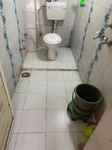 een badkamer met een toilet en een emmer op de vloer bij Sahu Home stay in Ujjain