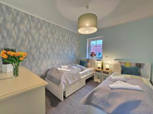 a bedroom with two beds and a vase of flowers at Friesenkate Steuerbord in Hagermarsch