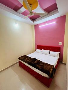 een bed in een kamer met een roze muur bij Sahu Home stay in Ujjain