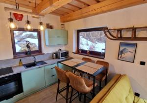 eine Küche und ein Esszimmer mit einem Tisch und Stühlen in der Unterkunft BALABO Kuča in Horná Lehota