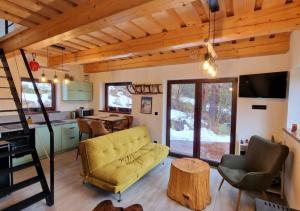 ein Wohnzimmer mit einem gelben Sofa und einem Tisch in der Unterkunft BALABO Kuča in Horná Lehota