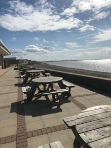 a row of picnic tables on the beach at Lazeeedays on Mersea Island in Colchester
