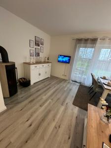 an empty living room with a table and a television at Inseloase in Fehmarn