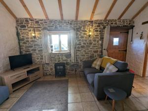 a living room with a couch and a tv at Immaculate 1-Bed Cottage in Bideford in Bideford