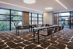 una sala conferenze con tavoli, sedie e finestre di Four Points by Sheraton Sydney, Central Park a Sydney