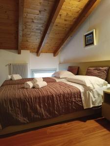 a large bed in a room with wooden ceilings at AmaMantua in Mantova