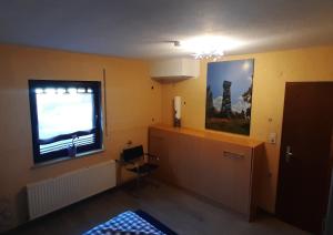 a room with a television and a window and a bed at Kellerwaldturm Apart-Room in Jesberg