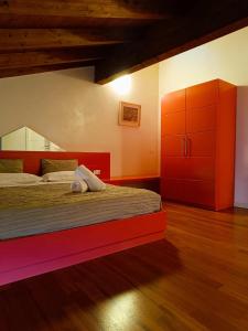 - une chambre avec un lit et une armoire rouge dans l'établissement AmaMantua, à Mantoue