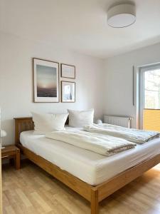 ein weißes Schlafzimmer mit einem großen Bett mit weißer Bettwäsche in der Unterkunft Ferienwohnung Ostseetraum Zinnowitz in Zinnowitz