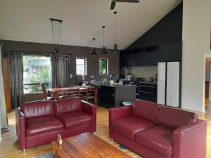 a living room with two red couches and a kitchen at Springfield Retreat in Springfield