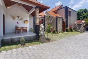 ein Haus mit einer Terrasse mit einem Tisch in der Unterkunft Ikada Villa by Pramana Villas in Ubud