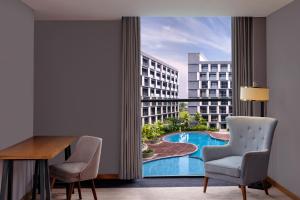 um quarto com vista para a piscina a partir de um quarto de hotel em Four Points by Sheraton Balikpapan em Balikpapan
