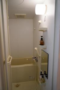a bathroom with a tub and a shower with a mirror at AMS海宝楼403 in Otaru +26 photos