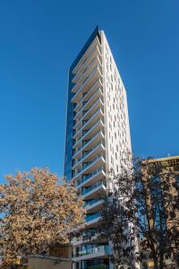 a tall building with a tree in front of it at Nicosia Central Park Residences in Nicosia