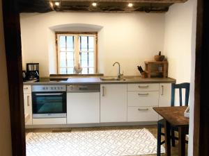 een keuken met witte kasten en een wastafel bij Sommerfrische Tschengls in Lasa