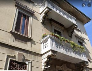 a building with a balcony with flowers on it at Chiarilù near the center Politecnico Fair and City Life in Milan