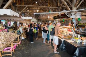 a group of people walking around a farmers market at HEUREUX HASARD in Clisson