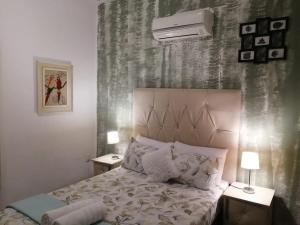 Palm View Guest House في بريتوريا: غرفة نوم مع سرير مع مواقف ليلتين ومصباحين