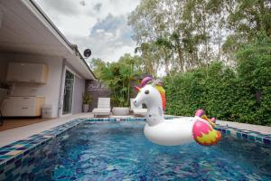 a swimming pool with a unicorn float in a house at Ioon Resort ไออุ่นรีสอร์ท in Sara Buri