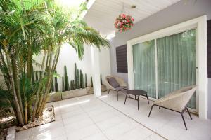 eine Terrasse mit 2 Stühlen, einem Tisch und Palmen in der Unterkunft Ioon Resort ไออุ่นรีสอร์ท in Sara Buri