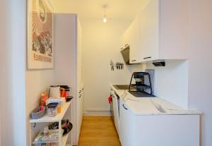 uma cozinha com armários brancos e uma bancada em Chic et Cosy - 5mn de la gare - Arrivée Autonome em Tours