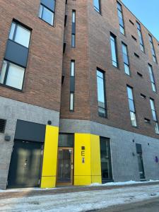 a brick building with yellow doors and windows at Studio VIP - close to airport and Tikkurila train station in Vantaa