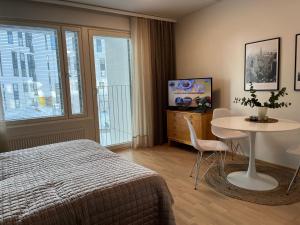ein Schlafzimmer mit Bett, Tisch und Fernseher in der Unterkunft Studio VIP - close to airport and Tikkurila train station in Vantaa