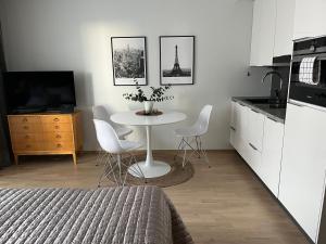 a kitchen with a table with chairs and a tv at Studio VIP - close to airport and Tikkurila train station in Vantaa