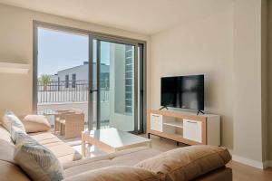 a living room with a couch and a flat screen tv at Sol de Abades Live Canarias in Abades