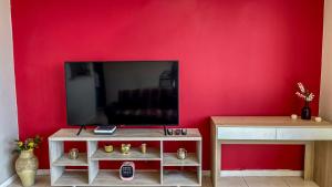 拉塞雷納的住宿－Departamento Costa Norte，客厅设有红色墙壁和平面电视