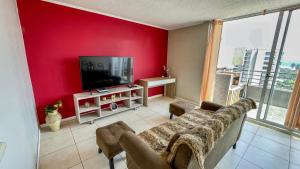 拉塞雷納的住宿－Departamento Costa Norte，客厅设有红色的墙壁和电视。