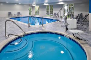 a pool in a hotel room with a large swimming pool at Four Points By Sheraton Mount Prospect O’Hare in Mount Prospect