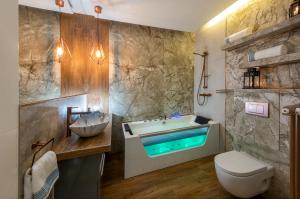 a bathroom with a tub and a toilet and a sink at Premium Apartment for Old Town & Jewish Quarter - Balcony, Jacuzzi and Pool in Krakow