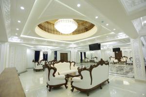 Duży pokój z białymi meblami i żyrandolem w obiekcie Ark Hotel w mieście Buchara