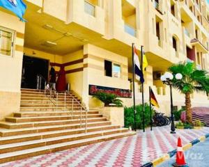 - un bâtiment avec des escaliers et des drapeaux en face dans l'établissement Florenza khamseen resort, à Hurghada