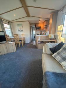 a living room with a couch and a kitchen at Coastal Caravan Holidays - Goldfinch 22 in Withernsea