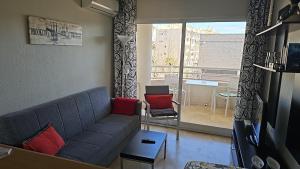 Albir Sunshine Apartments في البير: غرفة معيشة مع أريكة ونافذة