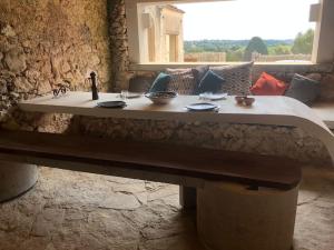 a bench in a room with a table and a window at oliveraie de caractère in Noto
