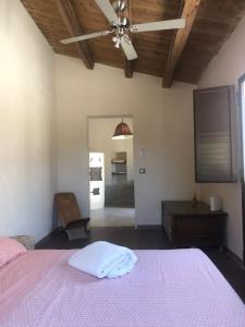 a bedroom with a pink bed with a pink blanket at oliveraie de caractère in Noto