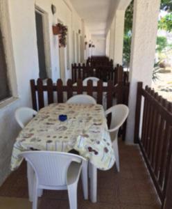 a table with white chairs and a table and a table and chairs at Residence La Quiete in Taureana