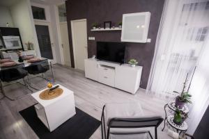 a living room with a television and a table and chairs at Apartman Day in Čakovec