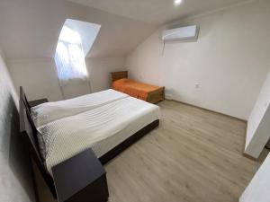 een kleine slaapkamer met een bed en een raam bij Marita in Batoemi