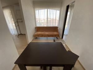 a black table and a brown chair in a room at Marita in Batumi