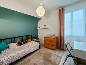 a bedroom with a bed and a dresser and a window at Appartement et Maison Espace Mayenne in Laval