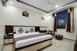 a bedroom with a large bed and a window at Capital O Hotel Pink Peral in Jaipur