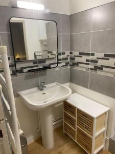 a bathroom with a sink and a mirror at La bella Vidda in Arromanches-les-Bains