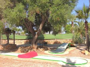 a playground with a slide and a tree at Can Ignasi in Can Picafort