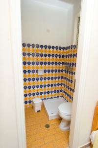 a bathroom with a toilet and a tiled wall at Malamatenia Studios in Loutra Edipsou +15 photos